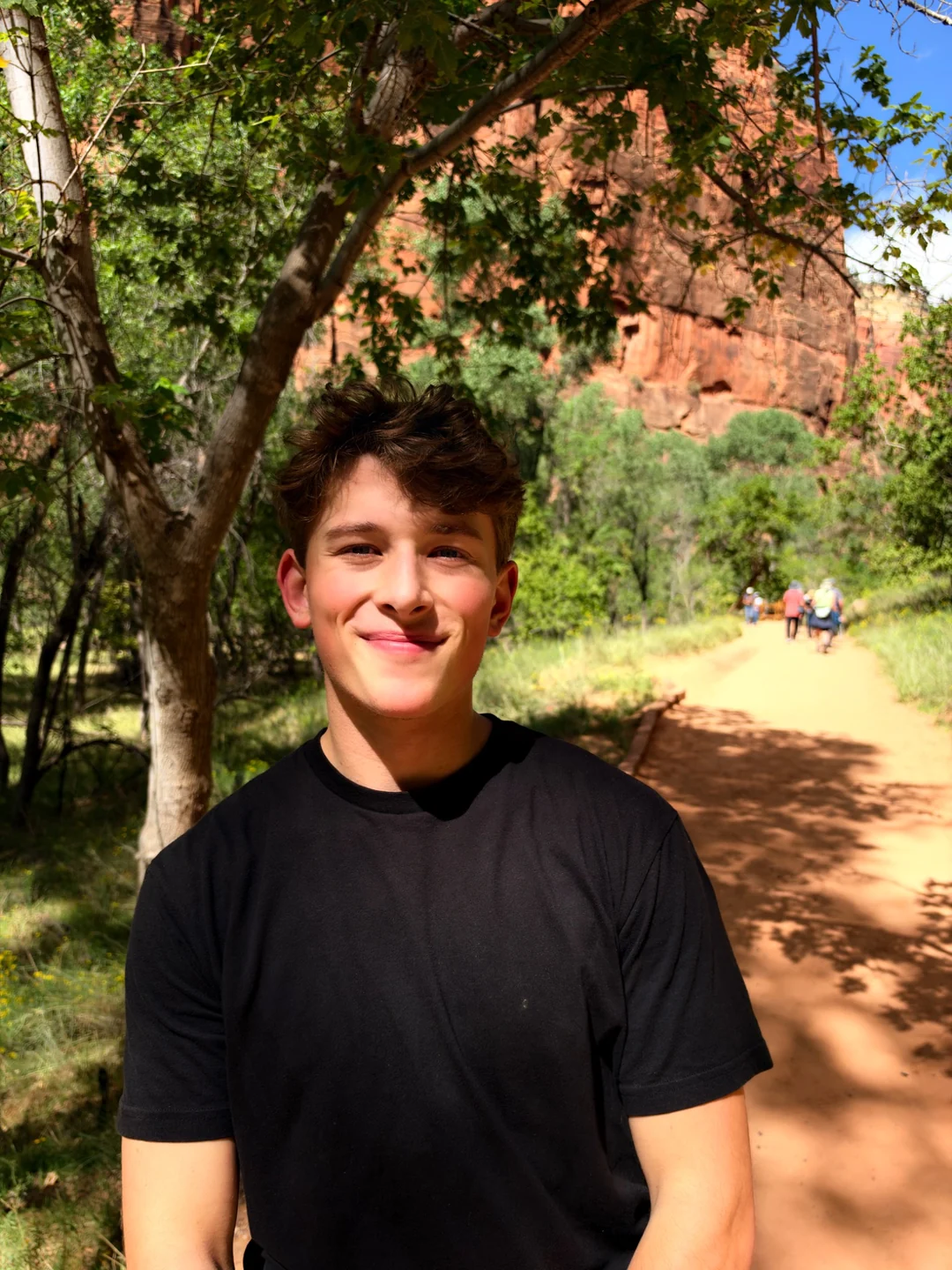Benji, founder of Foyer Film, smiling outdoors beneath the trees