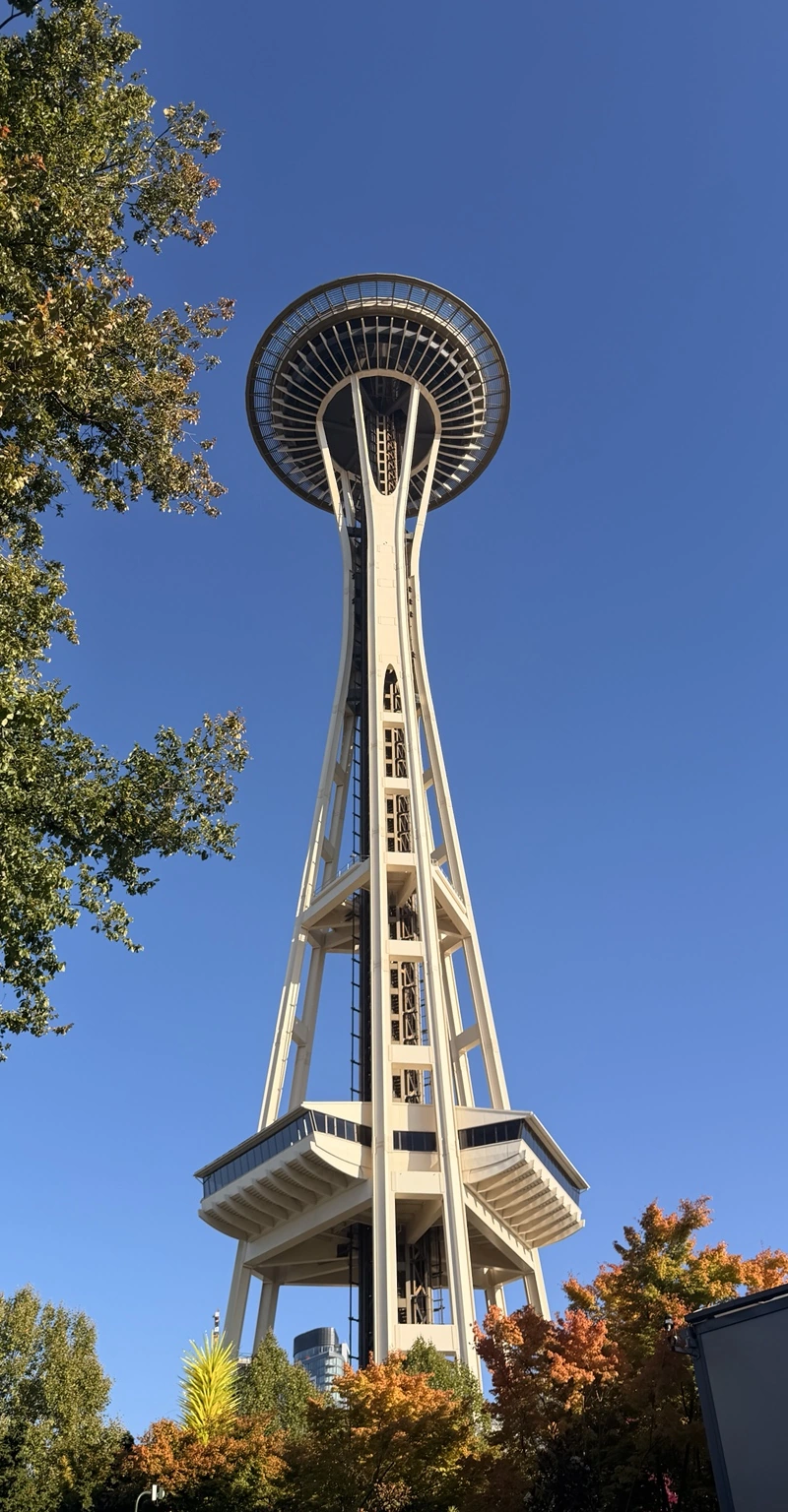 Personal photograph of Seattle’s Space Needle rising against blue sky, framed as a tall portrait